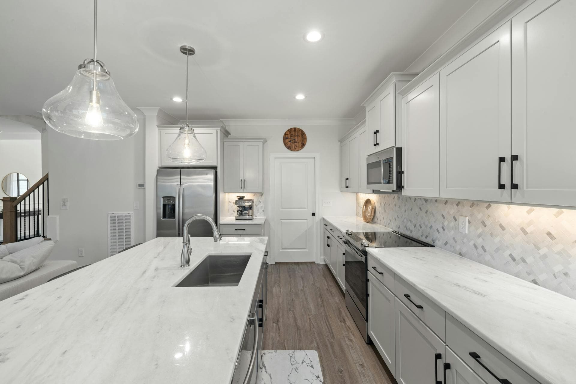 Bright white kitchen with a soft-veined marble waterfall island