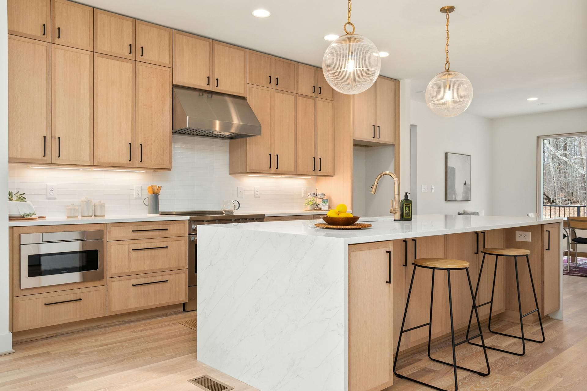 Warm modern kitchen with light wood and a white stone island