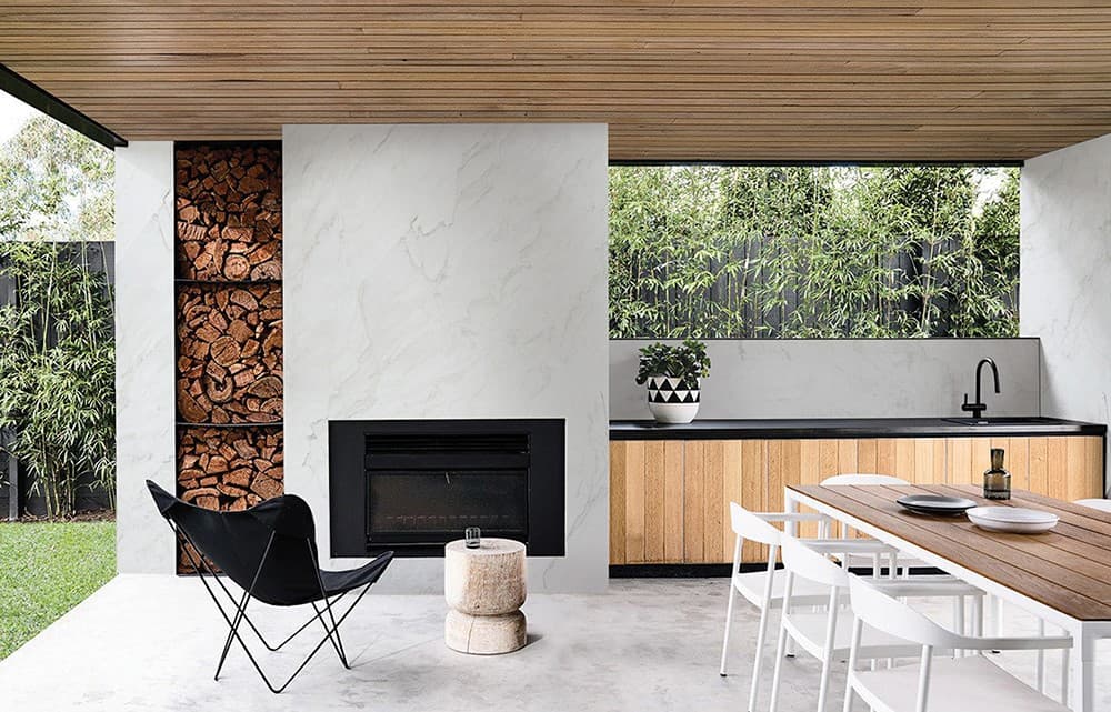 White quartzite slab fireplace in a covered outdoor living space