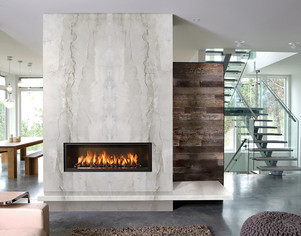 Floor-to-ceiling white-and-gray quartzite slab fireplace beside a wood accent wall